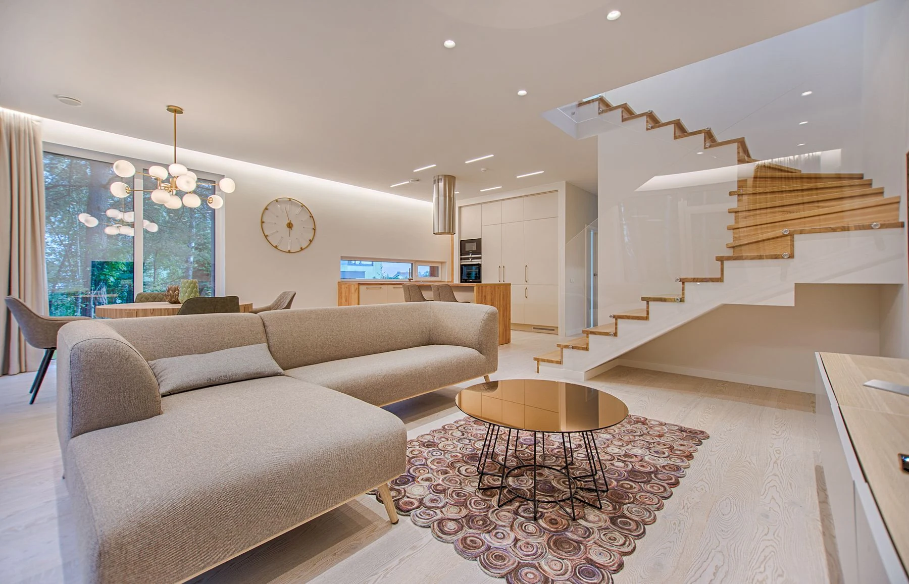 Elegant open-plan living room with a wood staircase