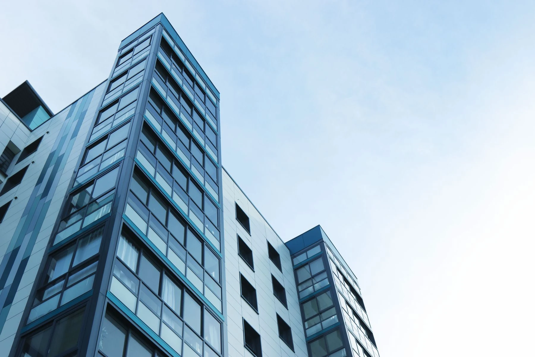 Modern glass buildings beneath an open blue sky